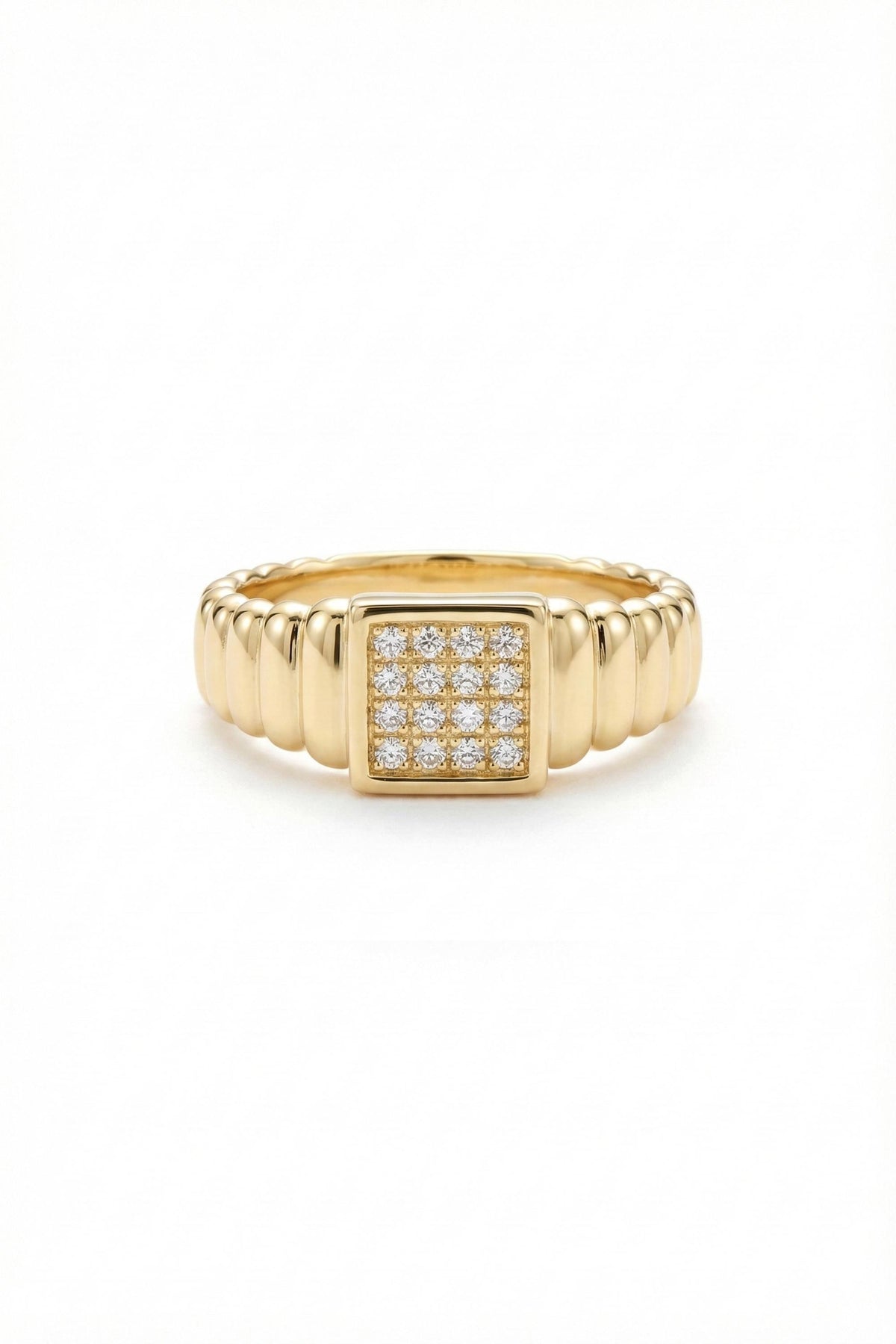 May include: A gold-colored ring with a square center featuring a cluster of small, clear stones. The band has a ribbed design, adding texture to the jewelry. The ring is set against a white background.
