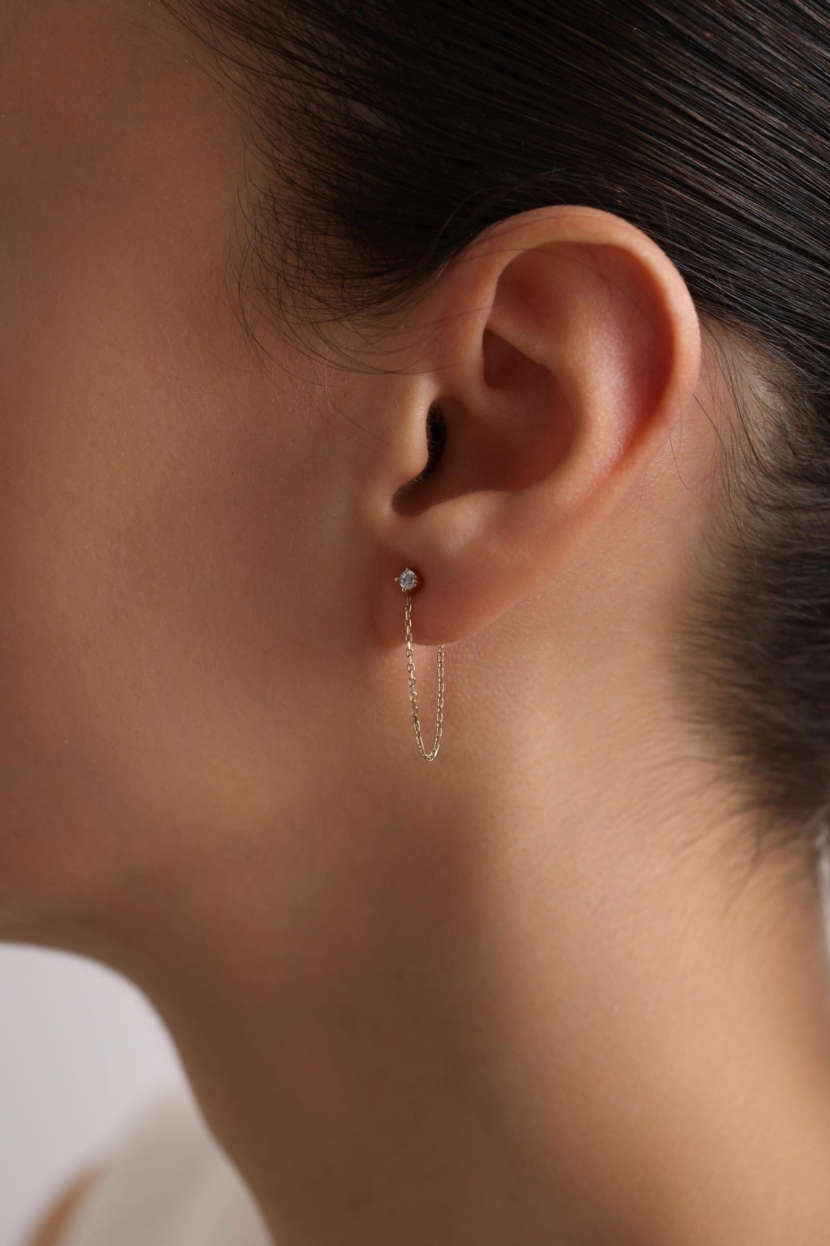 May include: A pair of gold chain earrings with a small diamond at the top of each chain.