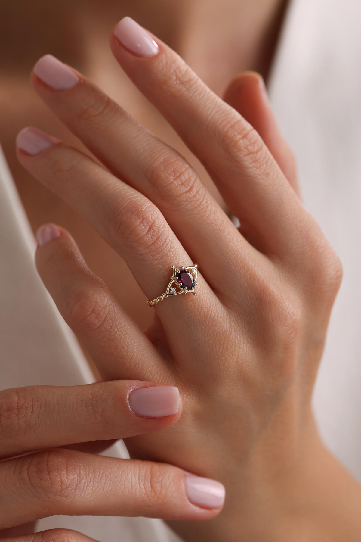 May include: A gold ring with a purple oval gemstone set in a delicate filigree design.