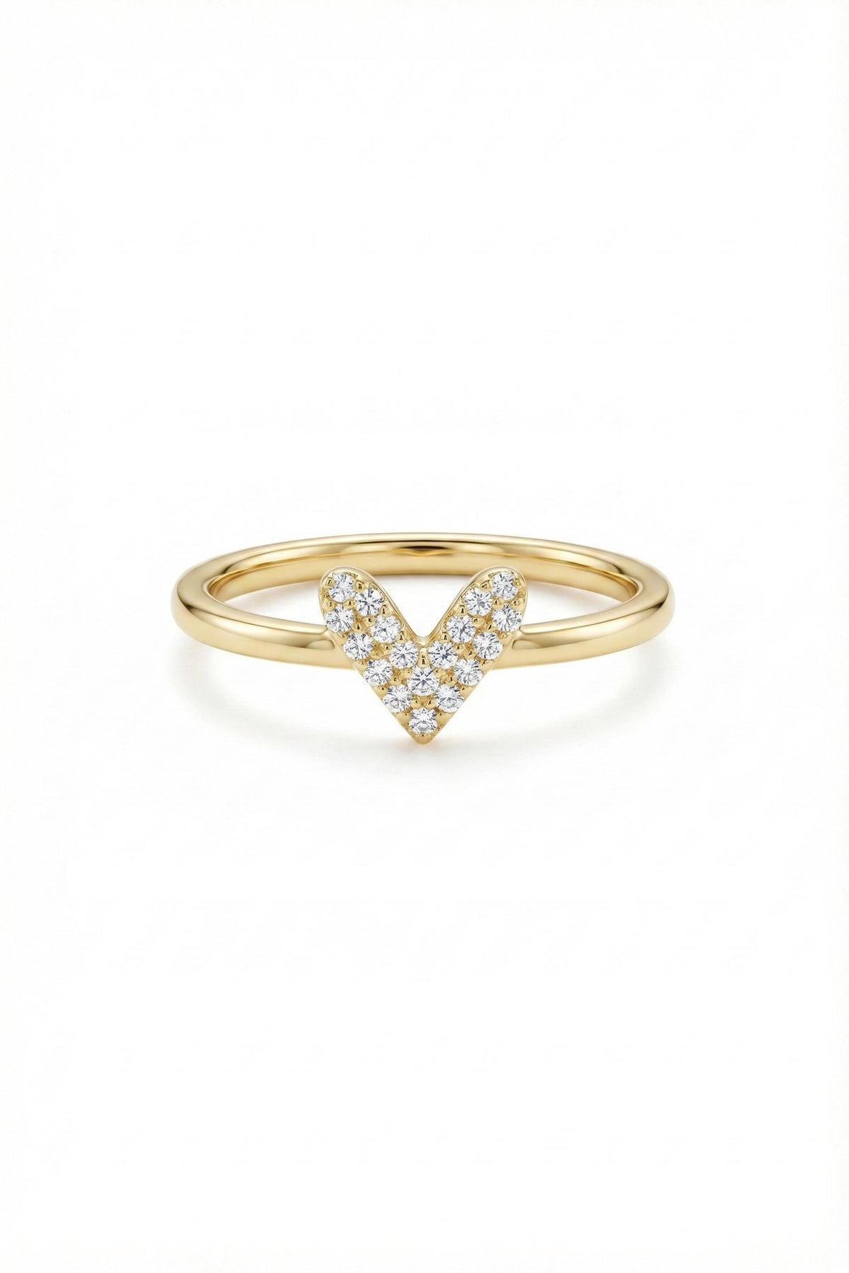 May include: A gold ring with a heart-shaped design. The heart is formed by small, sparkling diamonds set in a V-shape. The band is a smooth, polished gold. The ring is set against a white background.