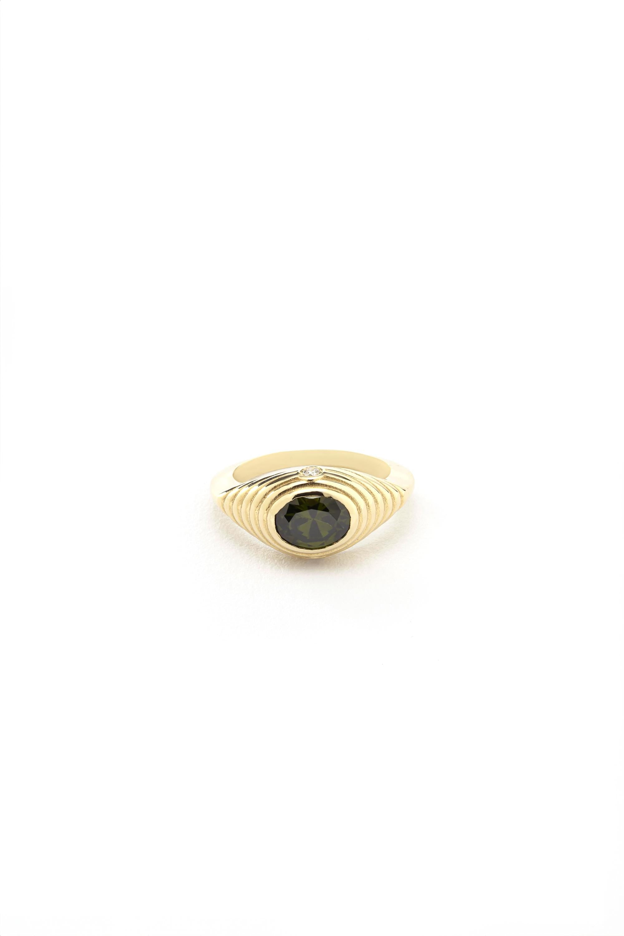 A gold ring with a large green gemstone in the center.